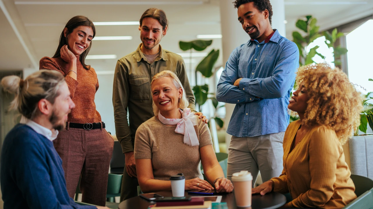 Leader joining employees for coffee in a workplace breakroom to encourage conversation and team connection